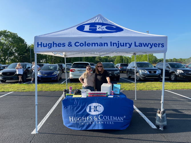 Two women at a booth for Bristow Safety Day for Hughes and Coleman Injury Lawyers