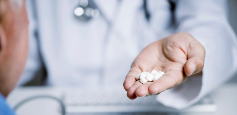 Pills spilling out of someone's hand, symbolizing drug injury cases.