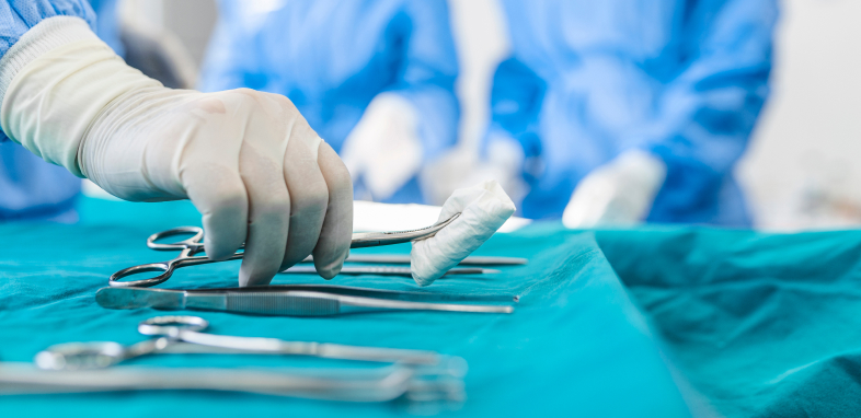 A doctor's gloved hand holding gauze in tweezers, representing medical malpractice cases